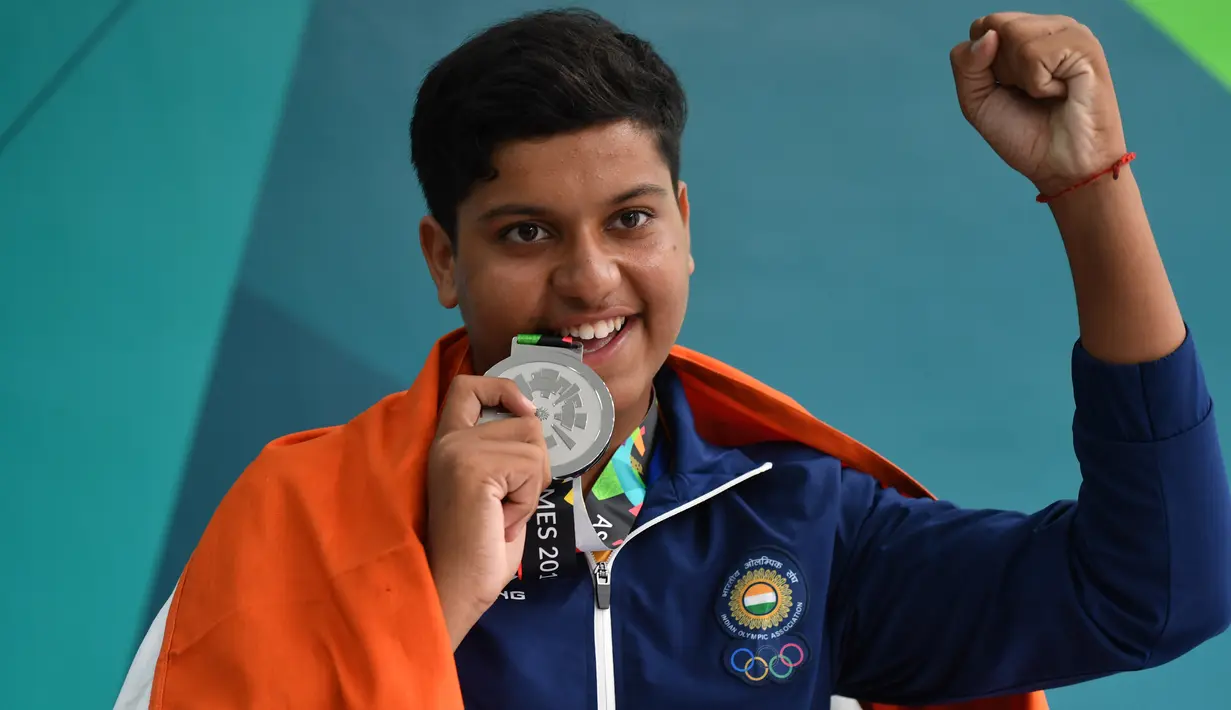 Penembak India, Vihan Shardul (15) berpose dengan medali perak usai menerima penghargaan di nomor double trap putra Asian Games 2018 di Palembang, Kamis (23/8). Shardul Vihan menjadi penembak terbaik kedua dengan catatan skor 73. (AFP/ADEK BERRY)