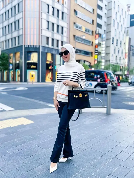 Kali ini pelantun lagu Sesuatu ini tampil simpel dengan kaus motif stripe yang dipadukan dengan celana jeans dan sepatu putih serta tas hitam. Gaya Syahrini makin chic ditambah kacamata hitam. (Liputan6.com/IG/@princessyahrini)