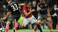 Gelandang Manchester United, Henrikh Mkhitaryan, berusaha melewati hadangan pemain Southampton. Pada laga ini MU melakukan 11 kali pelanggaran sementara Southampton hanya tujuh kali. (EPA/Peter Powell)