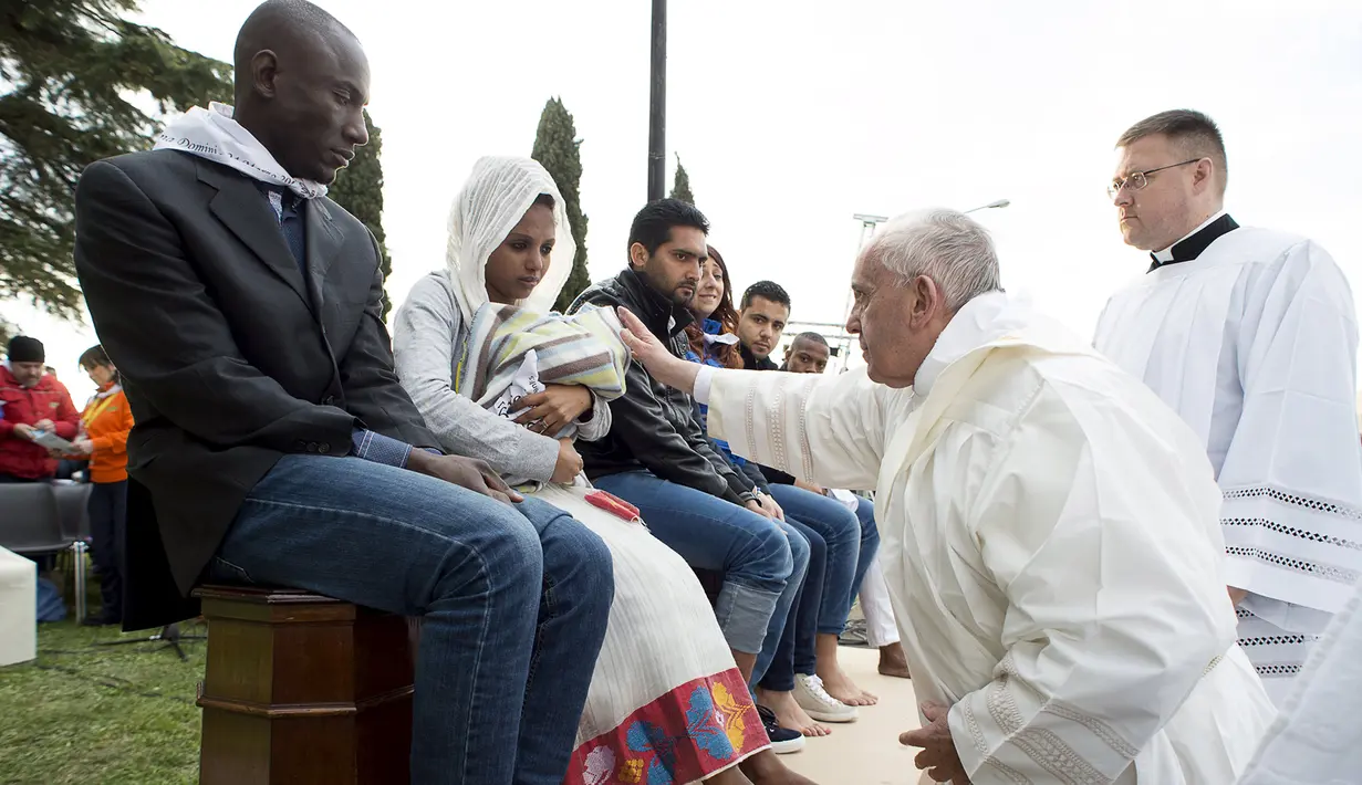 Paus Fransiskus mengusap kepala bayi di sela ritual pembasuhan kaki imigran di sebuah lokasi penampungan di Castelnuovo, dekat Roma, Italia, Kamis (24/3). Aksi tersebut dilakukan Paus sebelum memimpin misa Kamis Putih (Reuters/ Osservatore Romano)