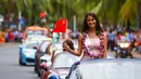 Kontestan Miss World dari Moldova tersenyum sambil membawa bendera China saat mengikuti pawai menggunakan supercar di Sanya, Provinsi Hainan, China, (7/11). Pawai ini membuka kontes kecantikan Miss World ke-67. (AFP Photo/Str/China Out)