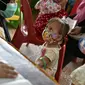 Seorang anak diukur tumbuh kembangnya sebelum menerima vaksin campak dan polio di sebuah posyandu di Banda Aceh, Aceh, Rabu (4/10/2020). Pemberian vaksin polio dan vaksin campak secara gratis yang berlanjut di tengah pandemi COVID-19 bertujuan memperkuat imunitas anak. (CHAIDEER MAHYUDDIN / AFP)