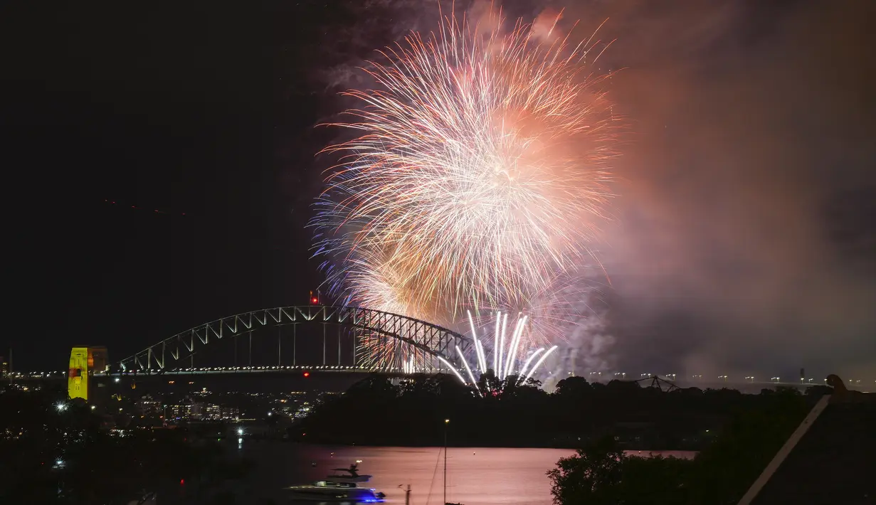 Kembang api meledak di atas Sydney Harbour saat perayaan awal Tahun Baru dimulai di Sydney, Minggu, 31 Desember 2023. (AP Photo/Mark Baker)