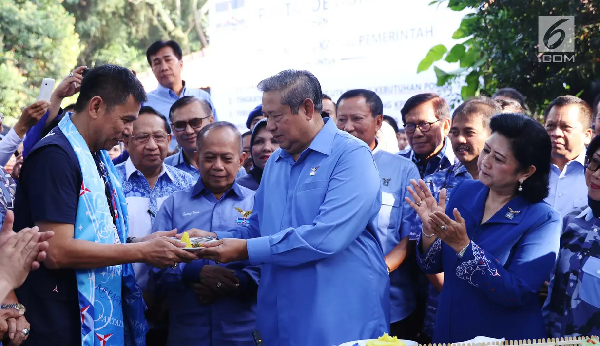 Ketua Umum Partai Demokrat Susilo Bambang Yudhoyono memberi potongan tumpeng kepada Sekjen Partai Demokrat Hinca Panjaitan saat perayaan HUT Partai Demokrat ke-16 di Cikeas, Jawa Barat, Sabtu (9/9). (Liputan6.com/Angga Yuniar)