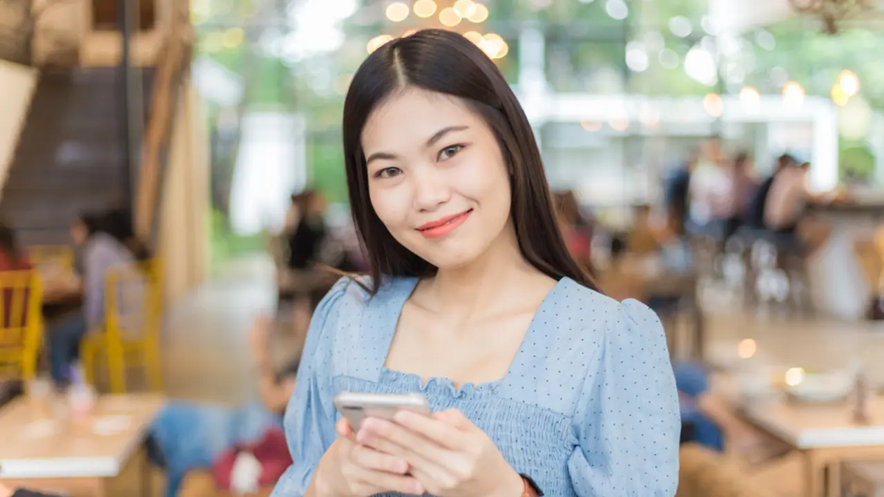 dewasa mandiri bahagia pegang handphone di kafe kalem