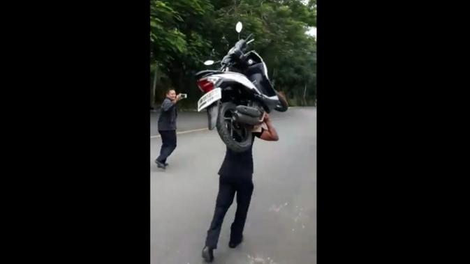 Seorang satpam RS Mayapada, Lebak Bulus, Jakarta Selata, viral setelah memindahkan motor yang parkir sembarangan dengan cara dipanggul. (Facebook Firman Wakkary)
