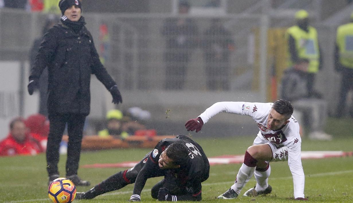Pemain AC Milan, Suso (tengah) saat dilanggar pemain Torino, Antonio Barreca (kanan) pada laga Coppa Italia di San Siro stadium, Milan (12/1/2017). Milan menang 2-1. (AP/Antonio Calanni)