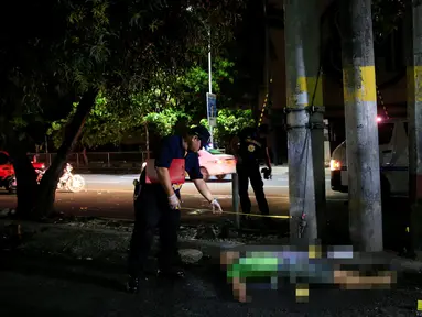 Petugas kepolisian Filipina (PNP) memeriksa jenazah pria yang ditemukan tewas di pinggir jalan Malate, Manila (29/8). Jenazah pria ini diduga sebagai bandar narkoba yang tewas dengan luka tembak. (REUTERS/Romeo Ranoco)