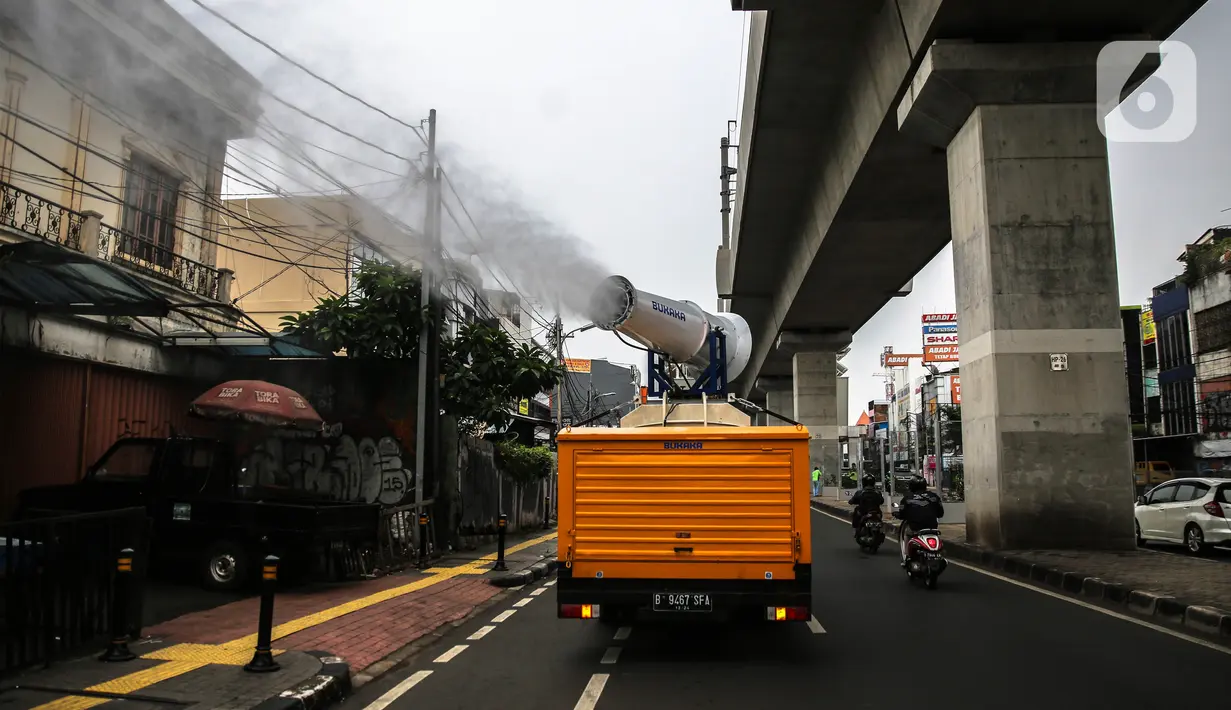 Petugas PMI dengan mobil gunners spraying menyemprotkan cairan disinfektan di kawasan Jalan Blok A, Jakarta, Kamis (30/4/2020). Untuk mencegah penyebaran COVID-19, PMI melakukan penyemprotan disinfektan berskala besar di wilayah DKI dengan memanfaatkan momen PSBB. (Liputan6.com/Faizal Fanani)