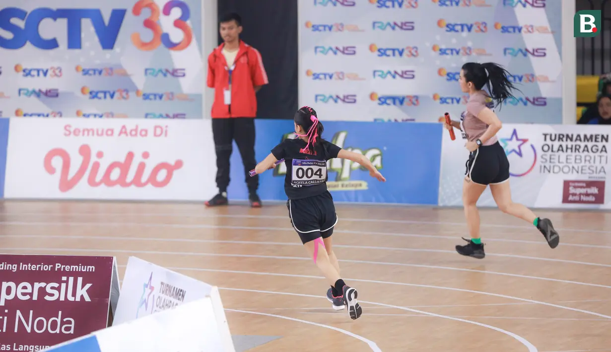 Selebritas Indonesia, Aqeela Calista (kiri) bersaing dengan Maria Vania saat berlomba pada cabang olahraga lari estafet 400 meter nomor campuran Turnamen Olahraga Selebriti Indonesia (TOSI) di GOR UNJ, Rawamangun, Jakarta, Minggu (30/07/2023). Timnya berhasil finis dengan catatan waktu 1 menit 0,59 detik. (Bola.com/Bagaskara Lazuardi)