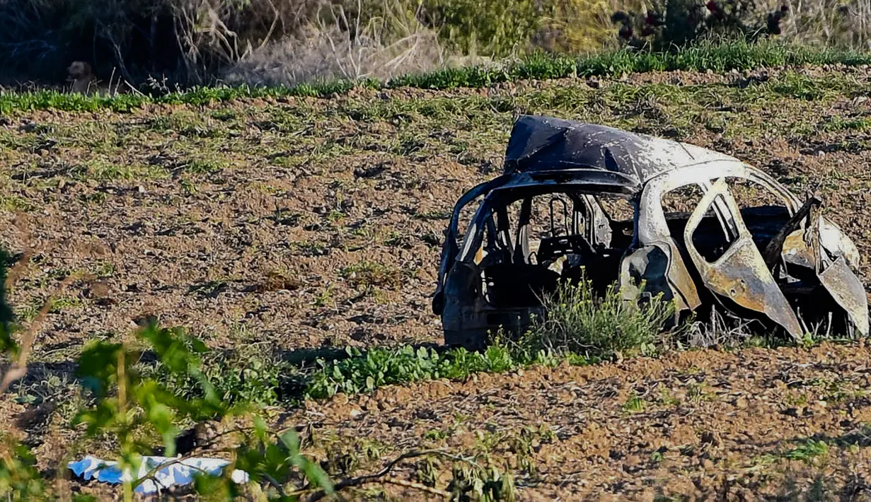 Bangkai mobil milik jurnalis investigasi, Daphne Caruana Galizia, tergeletak di pinggir jalan kota Mosta, Malta, Senin (16/10). Mobil jurnalis yang sebelumnya bekerja di Panama Papers itu dipasangi bom ketika tengah berkendara. (AP/Rene Rossignaud)