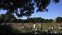 Orang-orang menikmati cuaca musim panas di Taman Englischer Garten, Munich, Jerman, 3 Agustus 2022. (AP Photo/Matthias Schrader)