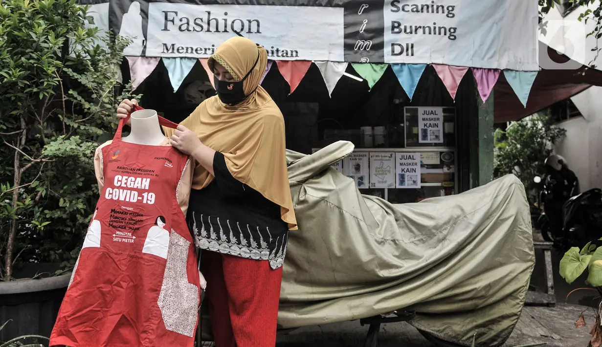 Siti Zahro (44) memajang celemek berbahan tas bansos Covid-19 buatannya di depan industri jahit rumahan KG-Lupe Fashion, Salemba, Jakarta, Senin (16/11/2020). Inovasi Siti bermula dari sepinya pesanan jahit akibat pandemi. (merdeka.com/Iqbal S. Nugroho)