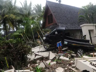 Mobil bak terbuka terseret pasca gelombang Tsunami Anyer di Tanjung Lesung Beach Resort, Pandeglang, Banten (23/12). BNPB mencatat hingga Minggu, pukul 16.00 WIB 222 orang meninggal dunia, 843 luka-luka dan 28 orang hilang. (merdeka.com/Arie Basuki)