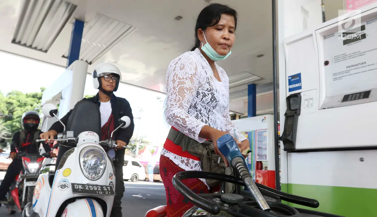 Petugas dengan pakaian adat mengisi bahan bakar minyak (BBM) untuk sepeda motor di SPBU, Bali, Rabu (10/10). Petugas SPBU mengenakan pakaian adat Bali untuk menyambut pertemuan tahunan IMF dan Bank Dunia. (Liputan6.com/Angga Yuniar)