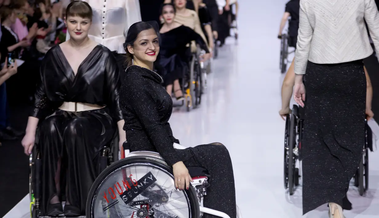Para model menggunakan kursi roda memperagakan busana desainer Tatyana Malchikova selama Moskow Fashion Week di Moskow, Kamis (23/3). Pagelaran itu didukung Open World, yayasan non profit yang berfokus pada penyandang cacat. (AP Photo/Ivan Sekretarev)
