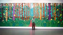 Pelukis asal inggris David Hockney berpose di depan lukisan besarnya di Perpustakaan Pompidou Center, Paris, Perancis, Selasa (26/9). Lukisan ini mencakup 32 panel dengan tinggi 3 meter dan lebar hampir 10 meter. (Foto AP/Francois Mori)