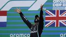 Pembalap Mercedes Lewis Hamilton melempar trofi ke udara saat merayakan kemenangan F1 GP Eifel di Nuerburgring, Nuerburg, Jerman, Minggu (11/10/2020). Hamilton dengan 91 kemenangannya menyamai legenda F1 Michael Schumacher. (Ronald Wittek, Pool via AP)
