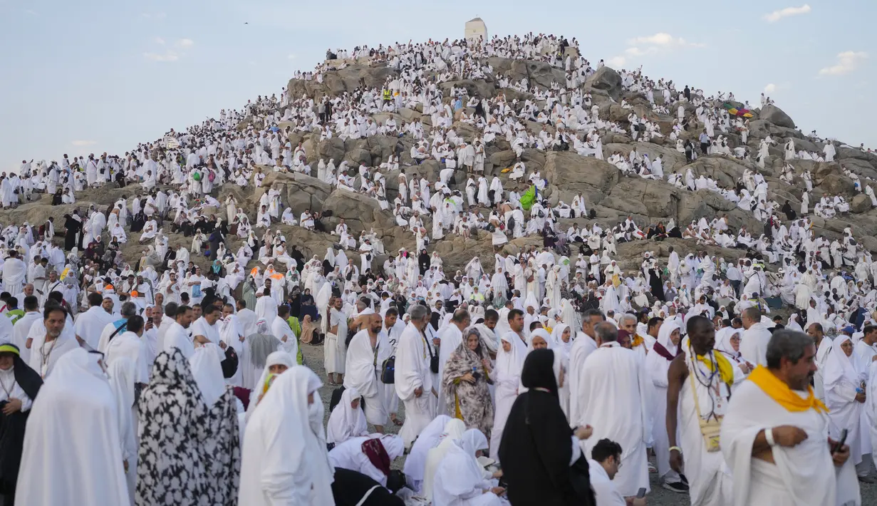 Umat muslim berkumpul di puncak bukit berbatu yang dikenal sebagai Gunung Rahmat di Dataran Arafah saat menunaikan ibadah haji dekat Kota Suci Makkah, Arab Saudi, Sabtu (15/6/2024). (AP Photo/Rafiq Maqbool)