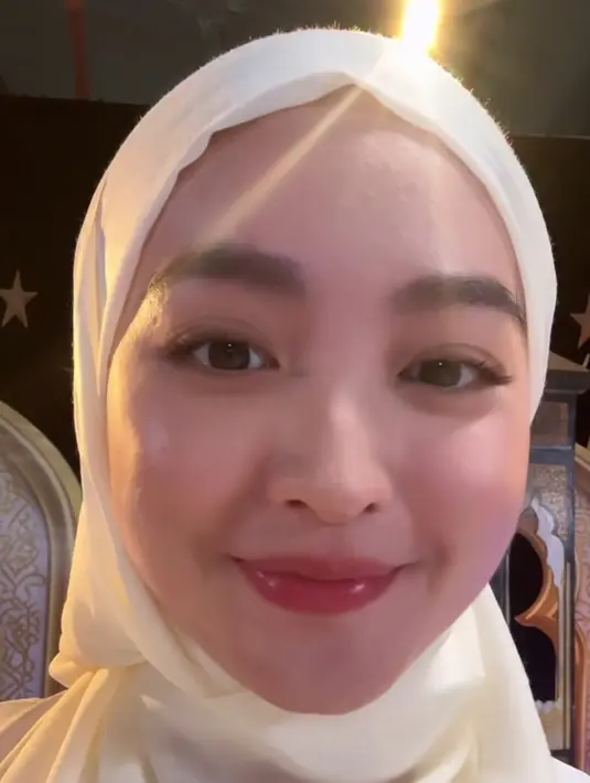 Wajahnya dipulas flawless glowing dengan blush on pink serta lipstick pink glossy. Riasan mata bahkan tanpa riasan hanya bulu mata yang sudah on fleek. [@natashawilona12]