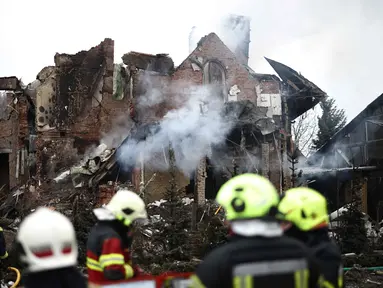 Para petugas penyelamat Ukraina berdiri di samping sebuah rumah yang rusak parah setelah serangan udara di Sofiivska Borshchagivka, wilayah Kyiv pada Minggu 22 Februari 2026. Rusia kembali melancarkan serangan besar-besaran menggunakan rudal dan pesawat nirawak (drone) ke wilayah pinggiran kota Kyiv. (Henry NICHOLLS/AFP)