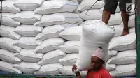 Seorang kuli angkut menurunkan beras dari atas truk di Pasar Induk Cipinang, Jakarta, Senin (25/9). Pedagang beras Cipinang sudah menerapkan dan menyediakan beras medium dan beras premium sesuai harga eceran tertinggi (HET). (Liputan6.com/Angga Yuniar)