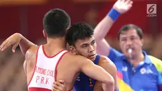 Pegulat putra Indonesia, Muhammad Aliansyah saat bertarung melawan pegulat Korea Utara Kim Myong Chol pada kelas putra 67 Kg di arena gulat JCC Senayan, Selasa (21/8). (Liputan6.com/Fery Pradolo)