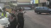 Anggota polisi bersenjata lengkap berjaga di lokasi ledakan di kawasan Ruko Grand Wijaya, Kebayoran Baru, Jakarta Selatan, Kamis (12/7). Sumber ledakan berasal dari lantai satu sebuah kantor konsultan hukum. (Liputan6.com/Ady Anugrahadi)