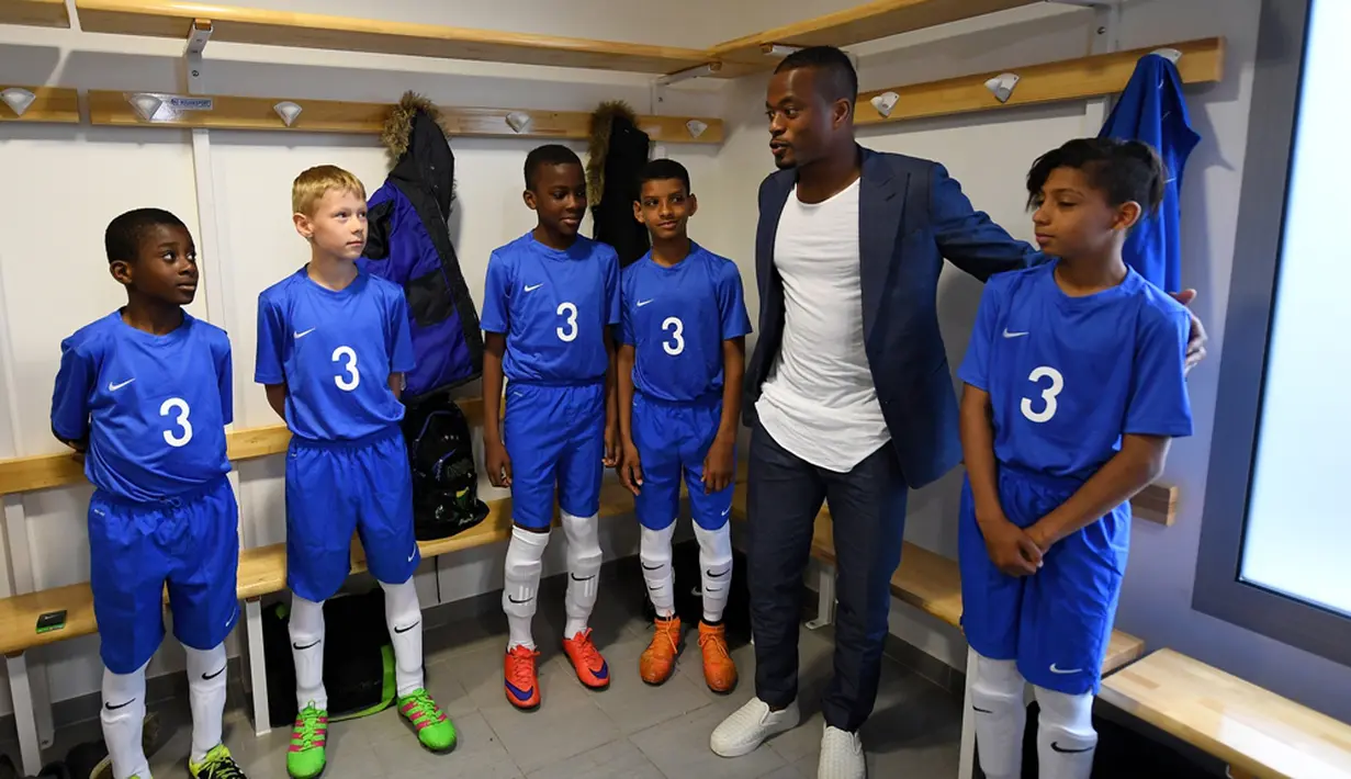 Pemain Timnas Prancis, Patrice Evra, memberi wejangan kepada para pemain muda Les Ulis di ruang ganti sebelum bertanding, (23/5/2016). (AFP/Franck Fife) 
