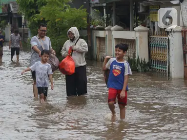 Warga melintasi genangan air di Perumahan Ciledug Indah 1, Kota Tangerang, Banten, Selasa (4/3/2025). (Liputan6.com/Angga Yuniar)