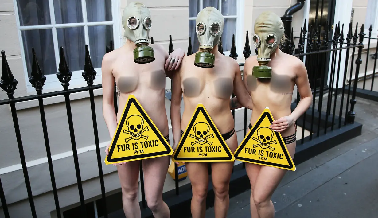 Sejumlah demonstran menggunakan masker gas saat unjuk rasa menolak London Fashion Week, Inggris (19/2). Aksi demo ini dilakukan didepan tempat berlangsungnya London Fashion Week 2016. (REUTERS / Neil Balai)