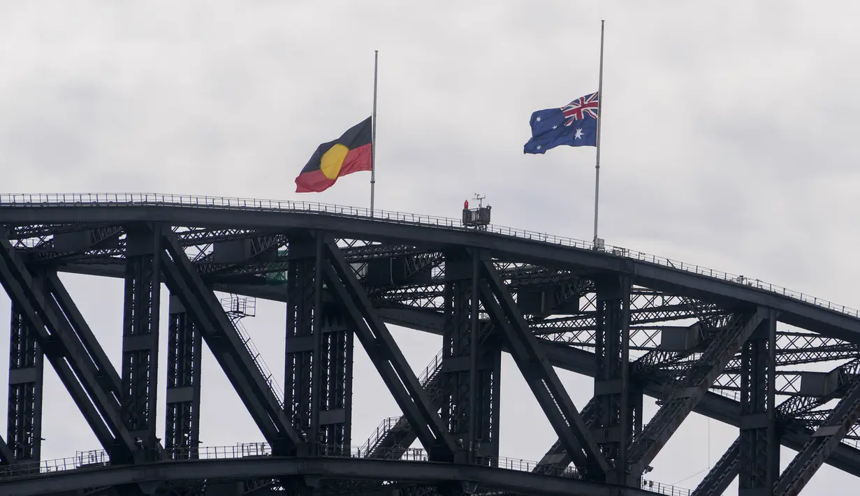 Bendera Australia dan Aborigin berkibar setengah tiang di atas Sydney Harbour Bridge menyusul wafatnya Ratu Elizabeth II di Sydney, Australia, Jumat (9/9/2022). Kepala negara dari seluruh dunia akan terbang untuk bergabung dengan anggota Keluarga Kerajaan untuk mengingat kehidupan dan pelayanan Ratu. (AP Photo/Mark Baker)