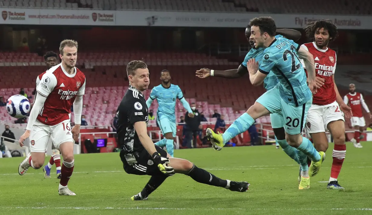 Pemain Liverpool Diogo Jota (kanan) mencetak gol ke gawang Arsenal yang dijaga Bernd Leno pada pertandingan Liga Inggris di Emirates Stadium, London, Inggris, Sabtu (3/4/2021). Liverpool membantai Arsenal dengan skor 3-0. (Adam Davy/Pool via AP)