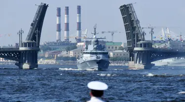 Seorang pelaut menyaksikan kapal perang Rusia berlayar selama parade Hari Angkatan Laut di Sungai Neva, Saint Petersburg, Rusia, Minggu (29/7). (Kirill Kudryavtsev/AFP)