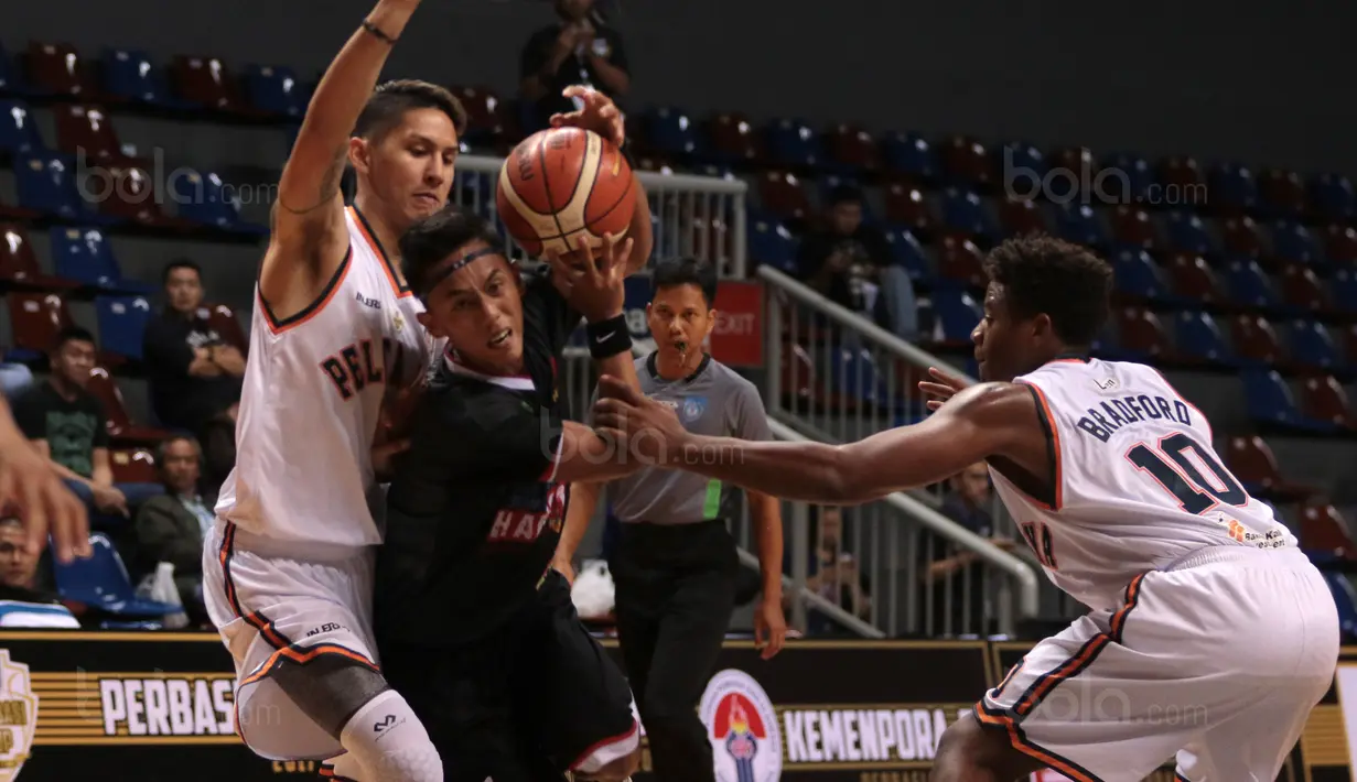 Pebasket Hangtuah Sumsel, Lucky Abdi (tengah) berusaha keluar dari adangan dua pemain Pelita Jaya pada laga Perbasi Cup 2017 di Sports Mall, Kelapa Gading, Jakarta, (09/11/2017). Pelita Jaya menang 67-58. (Bola.com/Nick Hanoatubun)