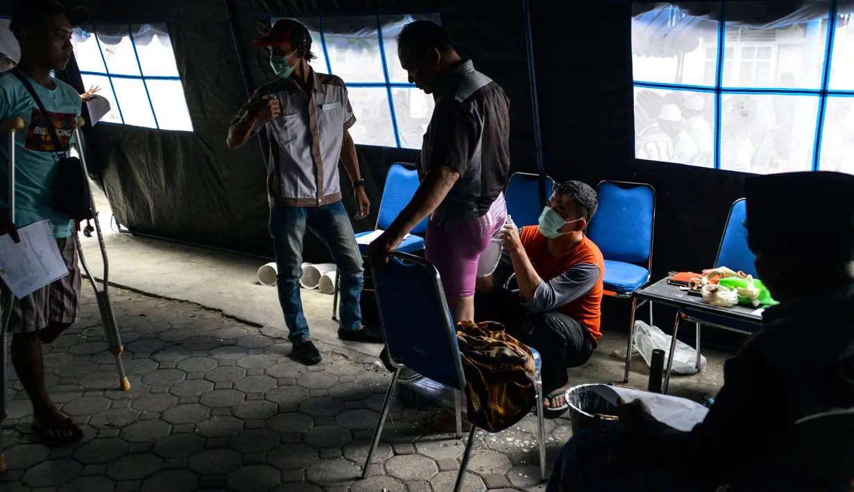 Petugas mengukur dan mencetak kaki palsu untuk seorang penyandang disabilitas di kantor Dinas Sosial Aceh, Senin (16/9/2019). Untuk tahun 2019 ini diberikan secara gratis sebanyak 100 kaki dan tangan palsu untuk para penyandang disabilitas di sejumlah kabupaten/kota. (CHAIDEER MAHYUDDIN / AFP)