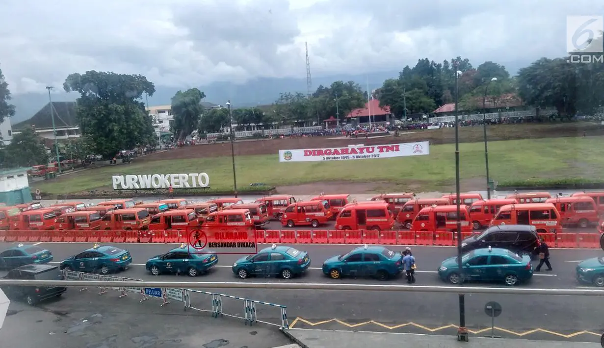 Ratusan taksi dan angkutan umum gelar aksi mogok tolak transportasi online di alun-alun Kota Purwokerto, Selasa (17/10). Mereka menuntut pemerintah melarang transportasi online di Banyumas. (Liputan6.com/Pool/ Dimas dan Neto Adrianto)