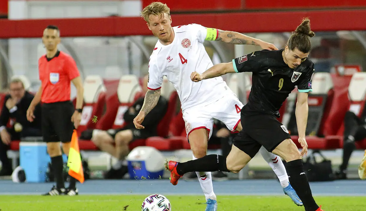 Pemain Denmark Simon Kjaer (kiri) memperebutkan bola dengan pemain Austria Marcel Sabitzer pada pertandingan Grup F kualifikasi Piala Dunia 2022 di Ernst-Happel-Stadium, Wina, Austria, Rabu (31/3/2021). Denmark membantai Austria 4-0. (AP Photo/Ronald Zak)