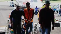 MD alias Darmawan (23) dikawal ketat polisi di bandara Ende (Liputan6.com/Ola Keda)