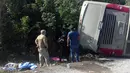 Petugas kepolisian dan paramedis memeriksa lokasi kecelakaan sebuah bus wisata yang terbalik di Quintana Roo, Meksiko, Selasa (19/12). Sebanyak 7 korban luka merupakan warga negara AS dan dua lainnya berkebangsaan Swedia. (Manuel Jesús ORTEGA CANCHE/AFP)