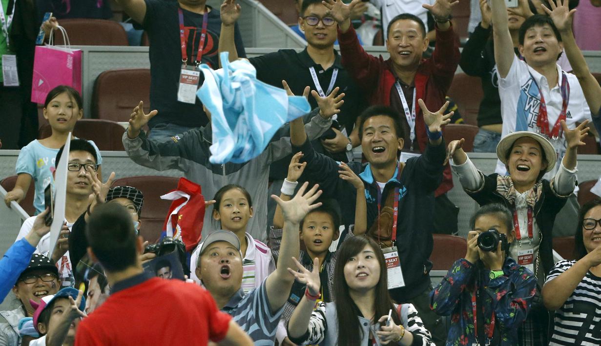 Petenis  Novak Djokovic melempar kaos ke arah penonton usai menang atas petenis Italia Simone Bolelli di China Open tennis tournament, Beijing, China, Selasa (06/10/2015).  (REUTERS/Kim Kyung-Hoon)
