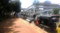 Satpol PP DKI Jakarta menertibkan baliho yang berdiri di atas trotoar depan Mapolda Metro Jaya, Jalon Gatot Subroto. (Liputan6.com/Nafiysul Qodar)