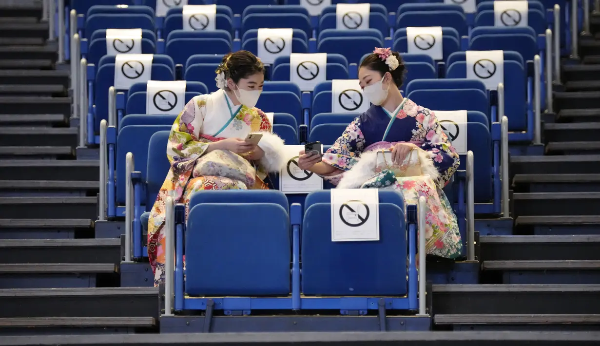 Perempuan Jepang berkimono yang merayakan ulang tahun ke-20 menunggu dimulainya upacara resmi, yang biasa disebut upacara Kedewasaan di Yokohama dekat Tokyo, Senin (9/1/2023). Diadakan setiap tahun pada hari Senin kedua di bulan Januari, pemerintah kota setempat merayakan Hari Kedewasaan atau Seiji no Hi. (AP Photo/Eugene Hoshiko)