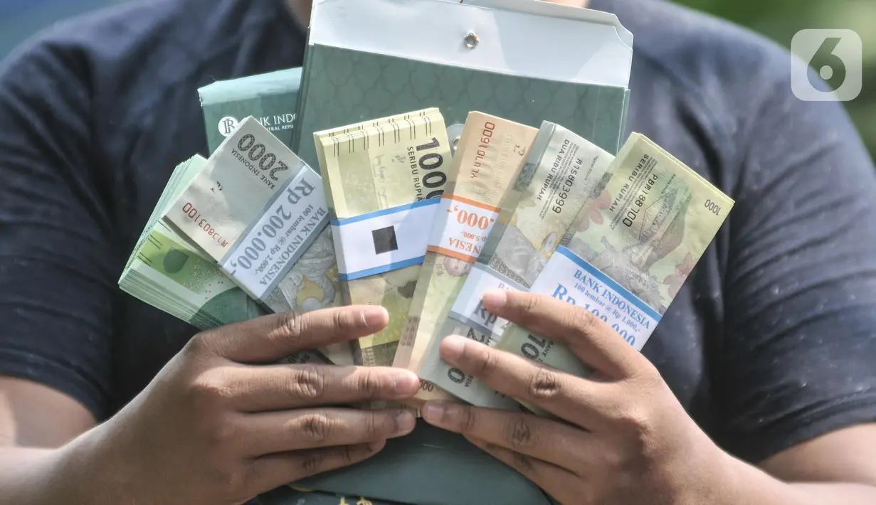 Warga menunjukkan uang pecahan kecil usai ditukarkan di mobil Kas Keliling BI, Pasar Rawa Bening, Jatinegara, Jakarta Timur, Senin (18/4/2022). BI menyiapkan 5.013 titik penukaran uang pada 262 bank umum di seluruh Indonesia sejak 4 April 2022 hingga 29 April 2022. (merdeka.com/Iqbal S.Nugroho)
