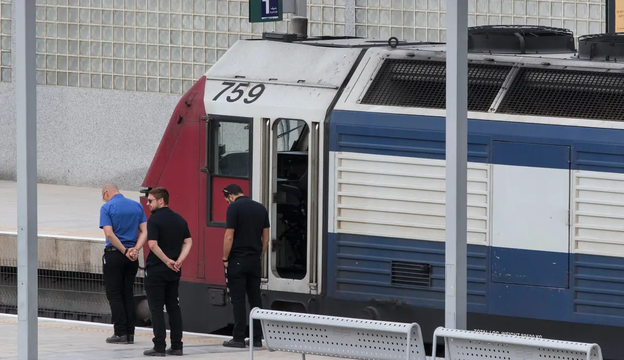 Petugas kereta api mengheningkan cipta ketika sirine panjang Hari Peringatan Holocaust berbunyi di Tel Aviv, Israel (24/4). (AFP Foto/Jack Guez)