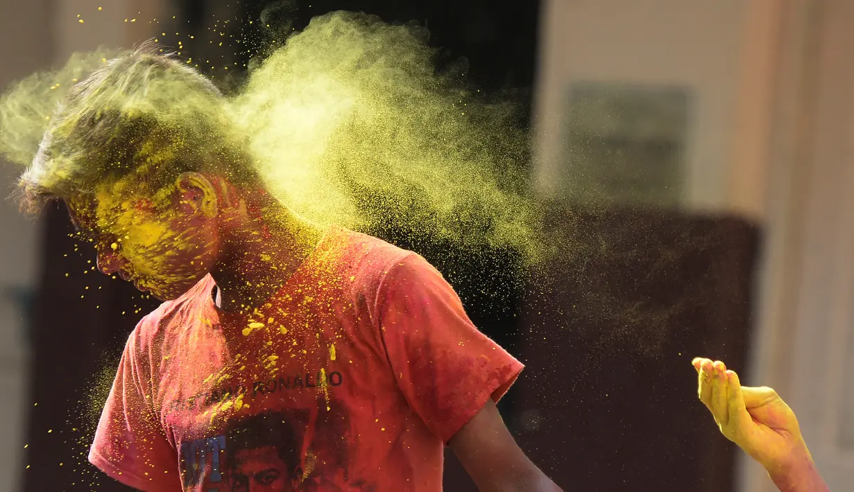 Seorang anak tunanetra dari The Devnar School for the Blind terkena bubuk berwarna selama merayakan festival Holi di Hyderabad (21/3). (AFP Photo/Noah Seelam)
