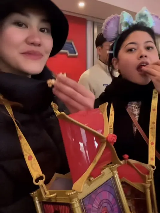 Keduanya pun kompak makan pop corn dengan tampilan gemas. Aaliyah mengenakan bucket hat hitam dan Pinka dengan bando minnie mouse. [@aaliyah.massaid]