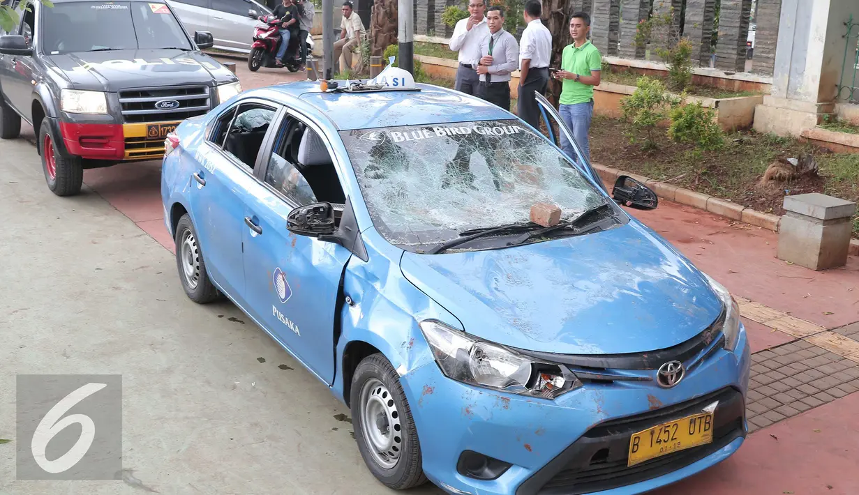 Mobil taksi yang hancur akibat dirusak oleh ojek online di Jakarta, Selasa (22/3).  Akibat aksi saling serang antara taksi dan ojek online berimbas pada kerusuhan yang terjadi di beberapa titik di Jakarta. (Liputan6.com/Angga Yuniar)