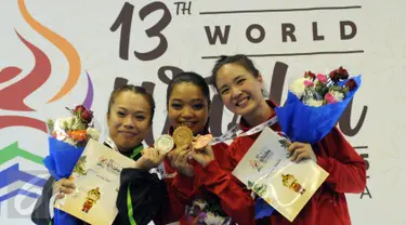 Atlet Wushu Indonesia, Juwita Niza WA (tengah) dan Ivana Ardelia (kanan) di podium kemenangan kelas Taulo Womens Nangun Kejuaraan Dunia Wushu ke-13 di Istora Senayan Jakarta, Selasa (17/11/2015). (Liputan6.com/Helmi Fithriansyah)