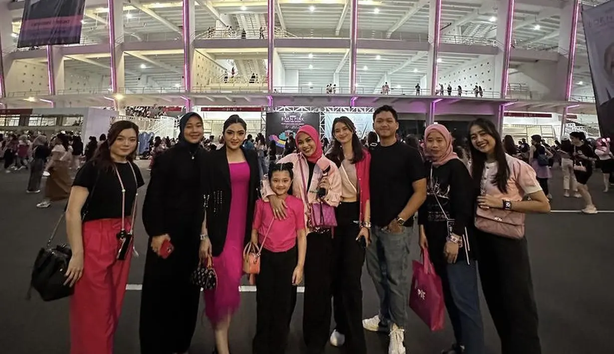 Aurel tampil dengan kemeja pink yang serasi dengan kerudung fushcianya. Dipadukan celana hitam dan sepatu hitamnya. 